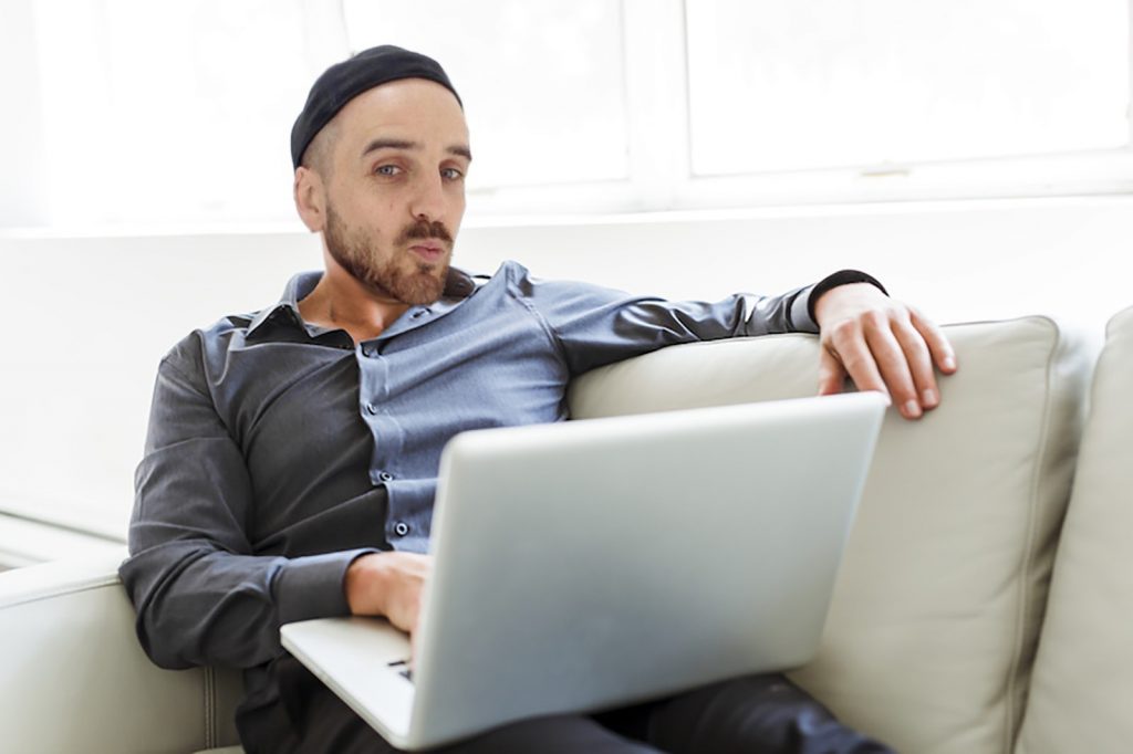 Young Relaxed Man Working On Laptop
