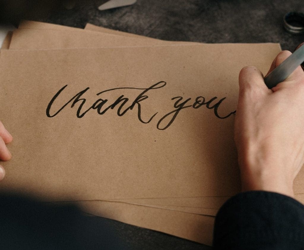 A woman writing thank you on a piece of paper